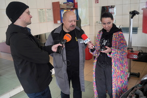 pracownik stacji obsługi pojazdów rozmawia z dziennikarzami