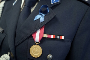 ujęcie na zawieszony medal na mundurze oraz zaczepioną niebieską wstążkę