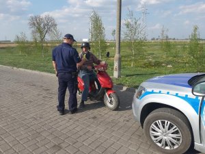 policjant sprawdza stan trzeźwości motorowerzysty