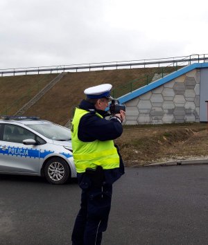 Policjant ruchu drogowego mierzy prędkość na drodze