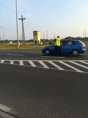 Policjant sprawdza stan trzeźwości kierującego samochodem osobowym