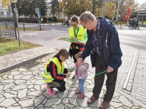 Druhy z OPS wręczają na ulicy odblask dziecku