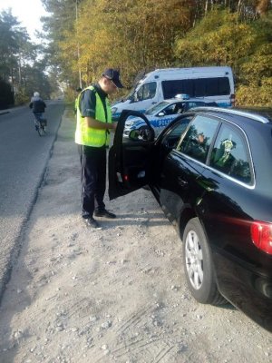 Policjant kontroluje kierowcę samochodu osobowego