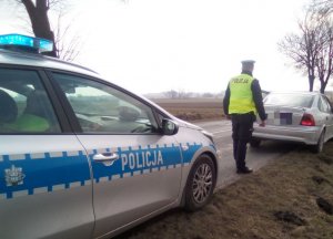 Policjant podchodzi do zatrzymanego pojazdu