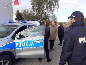 Policjanci i zaproszeni goście oglądają zakupiony radiowóz