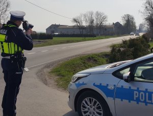 Policjant ruchu drogowego mierzy prędkość na drodze