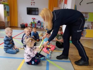 Policjantka przekazuje przedszkolakom odblaski