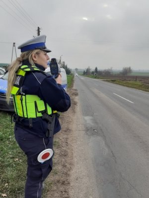 Policjantka mierzy prędkośc na drodze w trakcie działań &quot;Prędkość&quot;