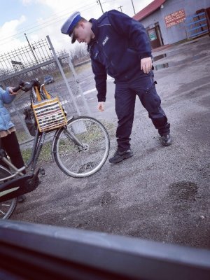 Policjant sprawdza wyposażenie roweru