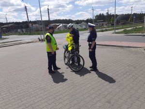 Policjanci i strażnicy przekazują kamizelki odblaskowe pieszym