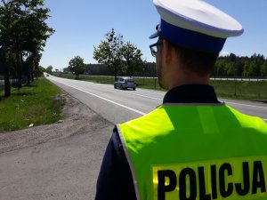 policjant obserwuje pojazdy na drodze