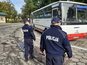 Policjanci na dworcu pks kontrolują teren pod kątem obowiązku noszenia maseczek