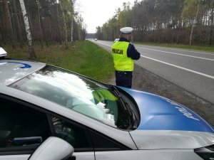 policjant dokonuje pomiaru prędkości na drodze