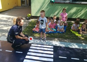 Policjantka uczy dziecko przejścia przez pasy