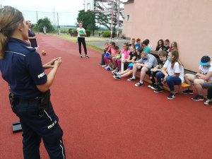 policjantka rozmawia z dziećmi na spotkaniu przedwakacyjnym