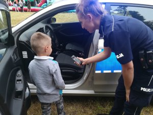 policjantka pokazuje dziecku radiowóz