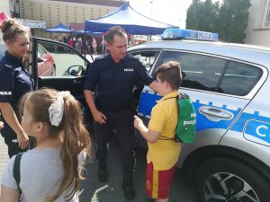 policjant rozmawia z dzieckiem na festynie