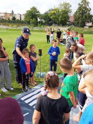 policjantka uczy dzieci przechodzić przez pasy