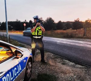 policjant mierzy prędkość na drodze