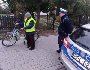 policjant i rowerzystka ubrana w kamizelkę odblaskową