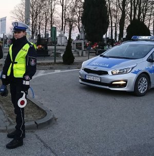 policjantka stoi w rejonie cmentarza