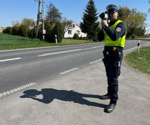 policjant mierzy prędkość na drodze