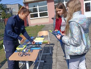 policjantka pokazuje uczniom ulotki