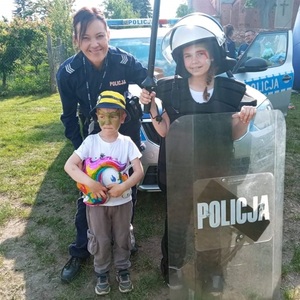 policjantka z dziećmi które przymierzają strój policyjny