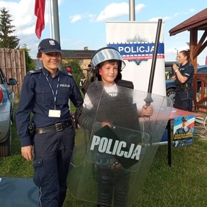 policjantka z dzieckiem przy stoisku profilaktycznym