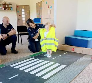 policjantka z dzieckiem w kamizelce odblaskowej