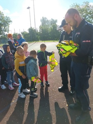 policjanci rozdają kamizelki odblaskowe