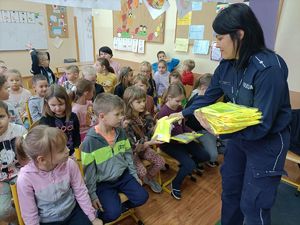 policjantka rozdaje kamizelki dzieciom