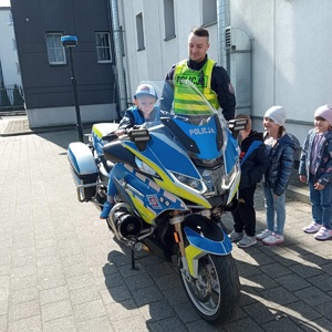 policjant pokazuje motocykl dzieciom