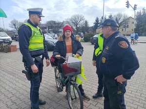 policjant wręcza kamizelkę odblaskową rowerzyście