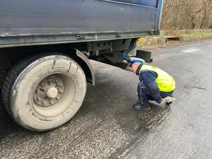 policjant sprawdza podwozie pojazdu