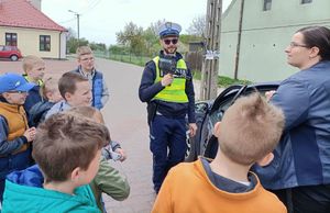 policjant pokazuje dzieciom z jaką prędkością poruszał się kierowca