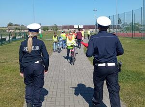 policjanci idą z dziećmi na plac manewrowy