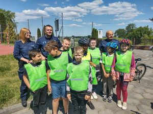 policjanci ze strażą i dziećmi w kamizelkach odblaskowych