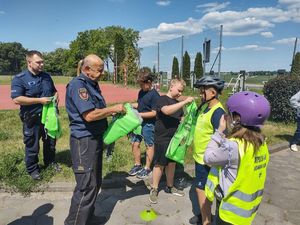 strażnik i policjant rozdają kamizelki