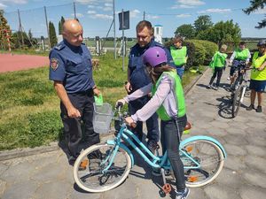 policjant sprawdza wyposażenie roweru