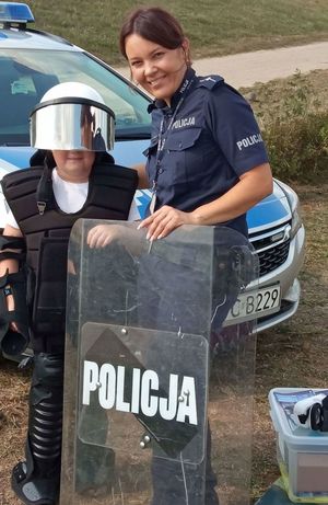 policjanta stoi z dzieckiem ubranym w mundur pezet