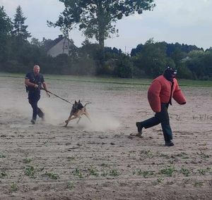 pozorant biegnie za nim pies i policjat