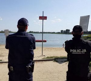 policjanci stoją kontrolują niestrzeżone kąpielisko