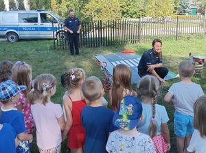 policjantka rozmawia z dziećmi przy macie pasów