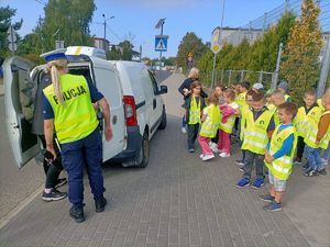 policjantka kontroluje pojazd, dzieci obserwują z ulicy