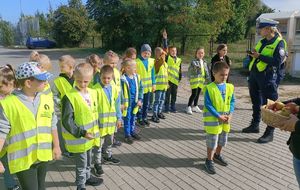 dzieci stoją na chodniku z cytryną i jabłkiem