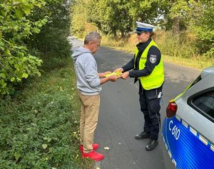 policjantka przekazuje mężczyźnie odblask