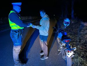 policjant przekazuje motorowerzyście odblaski