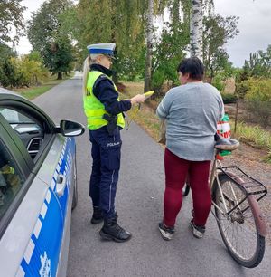 policjantka przekazuje kamizelkę odblaskową rowerzystce