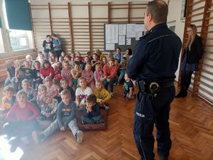 policjant stoi przed grupą dzieci